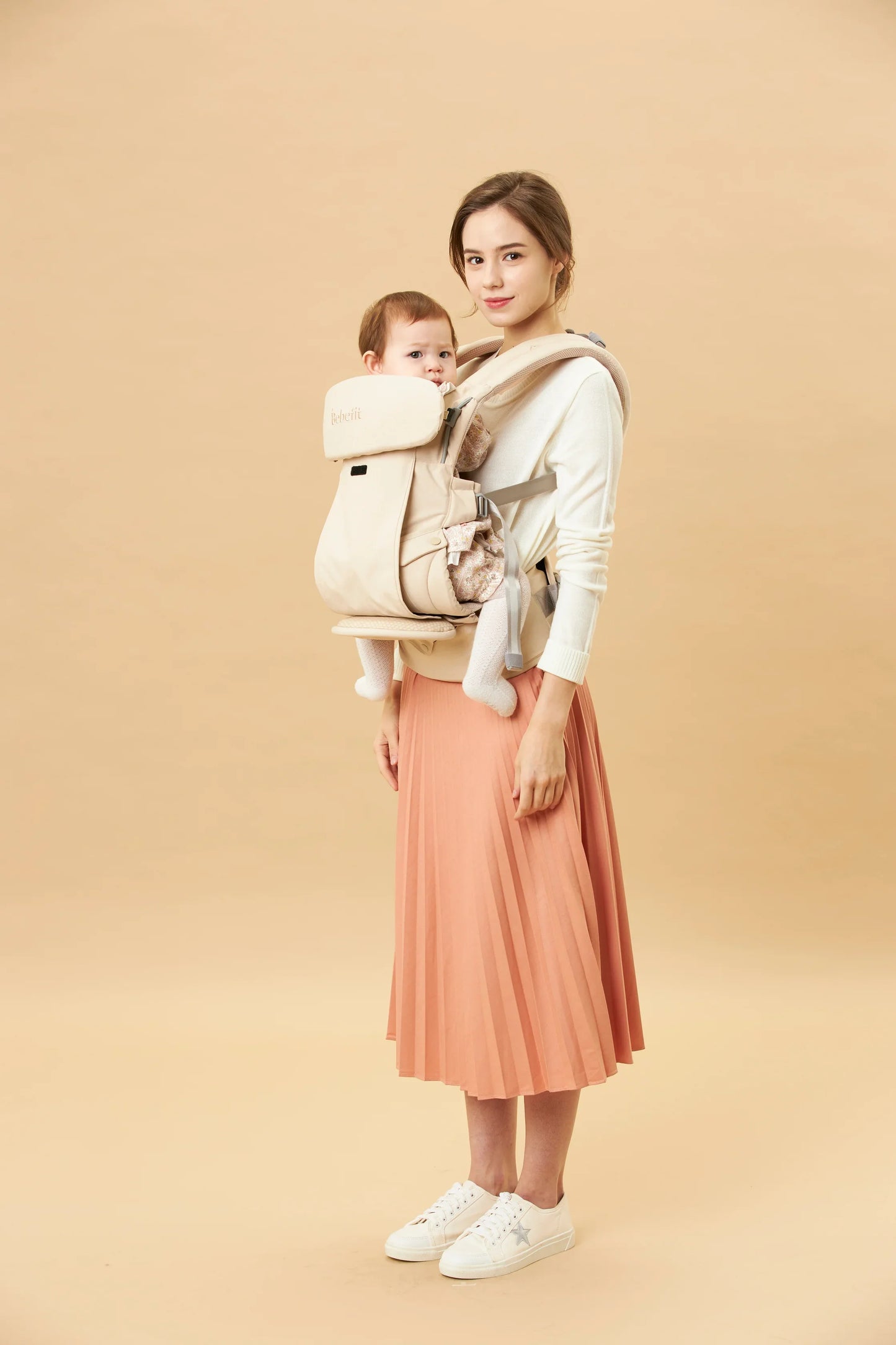 Mother carrying baby in ergonomic cream baby carrier, bebefit.eu, ergonomic baby carrier